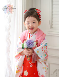 3歳女の子、白のお被布に可愛い小花がお似合いです!髪飾りは赤のつまみかんざしがアクセントになっていますね