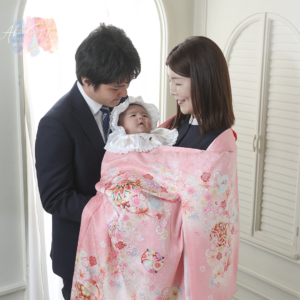 桜色の優美なお着物に身を包んだ赤ちゃんの、愛らしい表情との出会いは、私たちスタッフにとっても心温まるひとときとなりました。
白いおぼうしから覗く愛らしい表情と、ピンク色のお着物が調和した一枚。