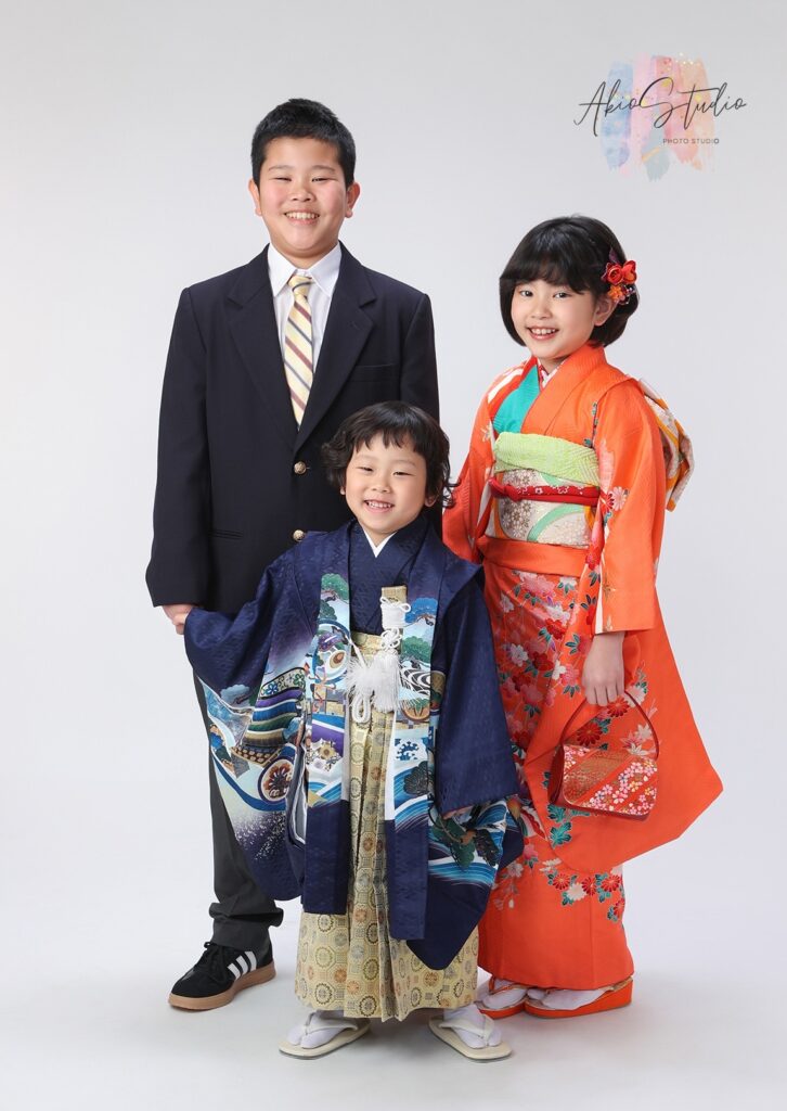 鮮やかなオレンジの着物を身にまとったお姉ちゃんと、凛々しいスーツ姿のお兄ちゃん、そして深い紺色の晴れ着に身を包んだご主役様。