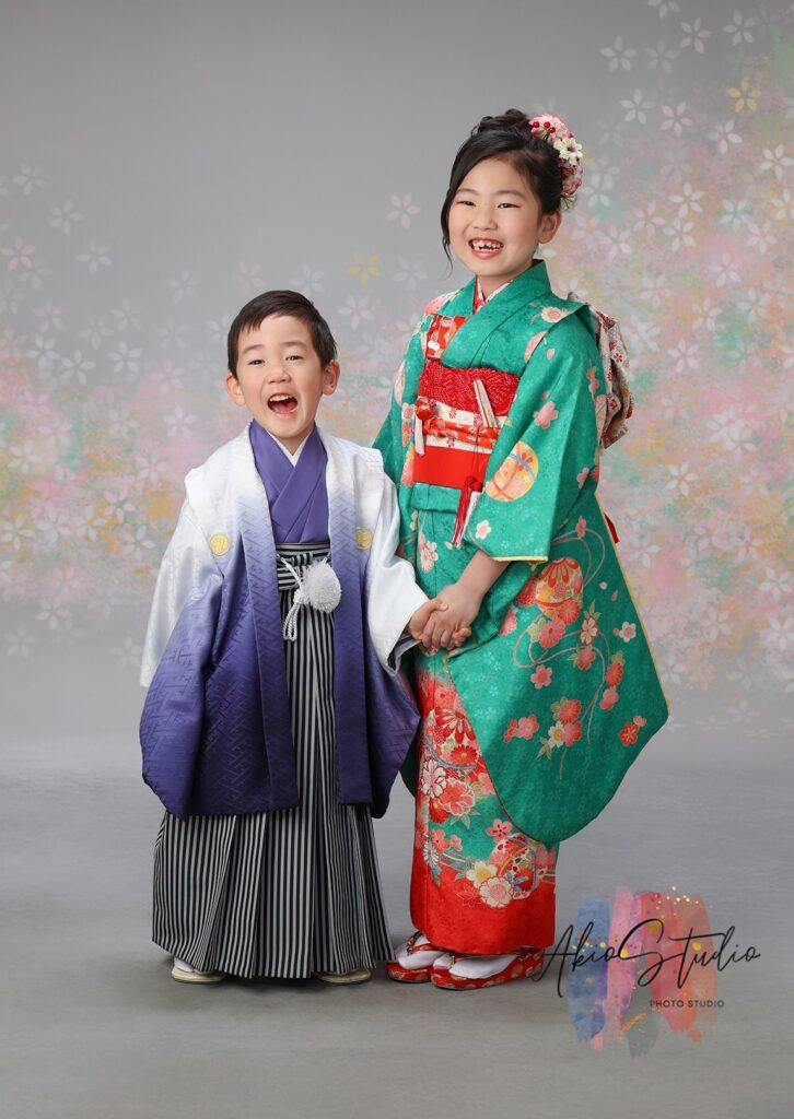 鮮やかな緑色の七五三着物を身にまとったお嬢様と、白と紫のグラデーションが美しい羽織袴姿の弟さん。